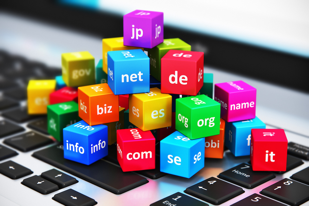 Internet and domain names concept Creative abstract global internet communication PC technology and web telecommunication business computer concept: macro view of group of color cubes with domain names on laptop or notebook keyboard with selective focus effect